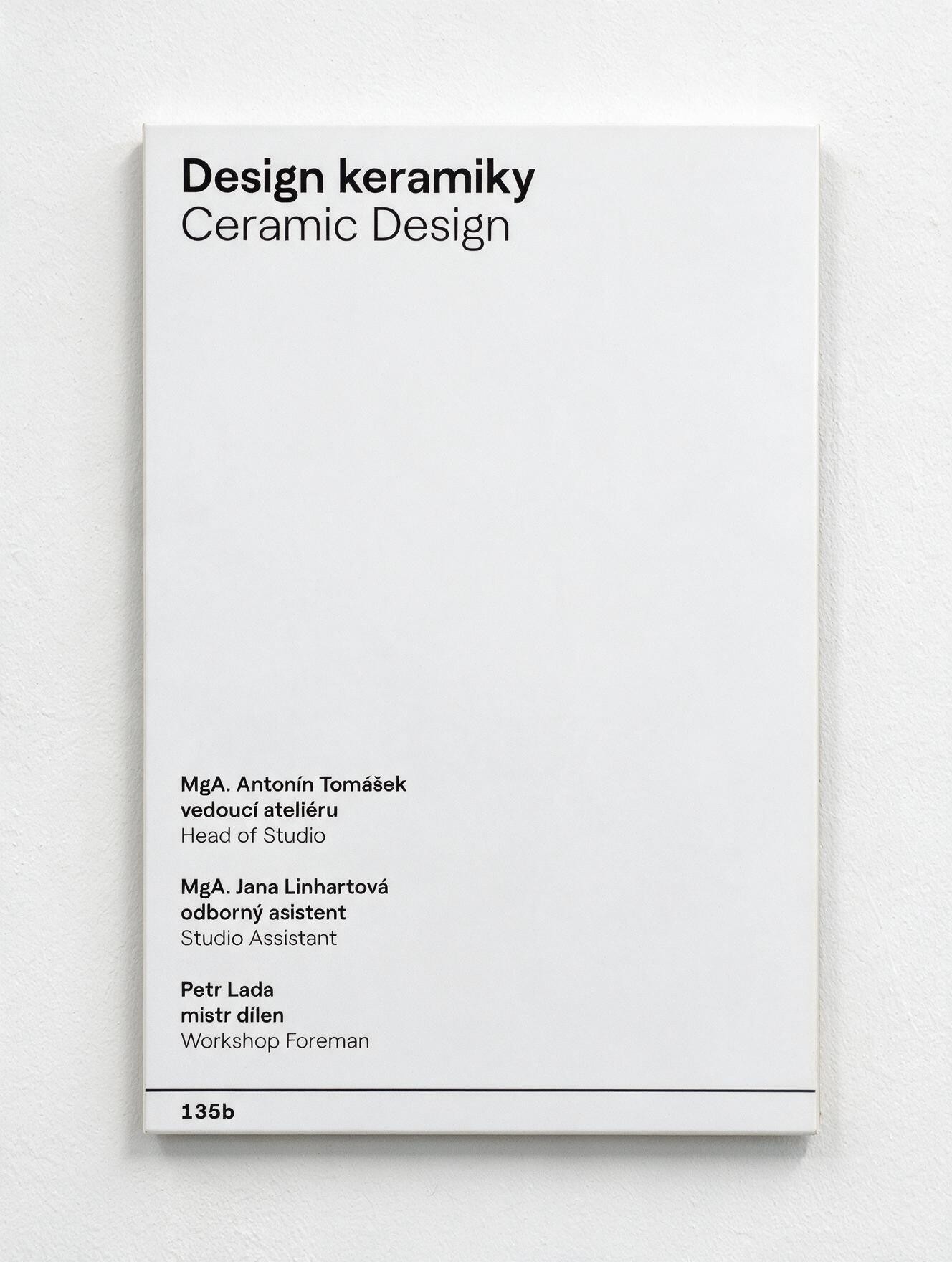 A white door plate reading 'Design keramiky / Ceramic Design' with staff names and room number 135b