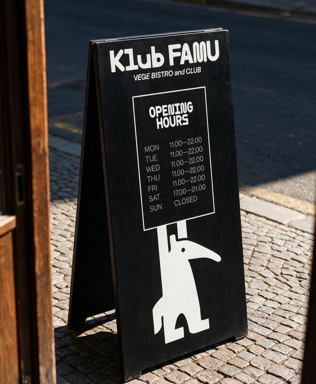 A hand holding a phone displaying the KlubFamu Instagram profile
