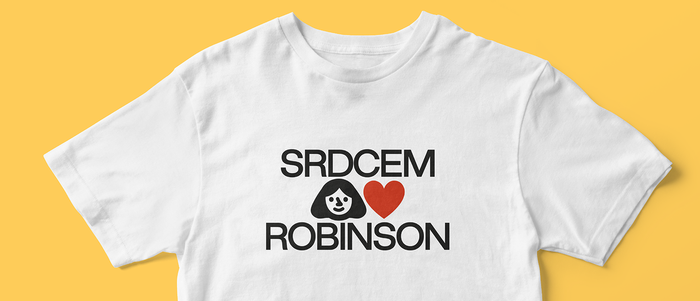 A white t-shirt printed with the Srdcem Robinson logo, laid on a yellow background